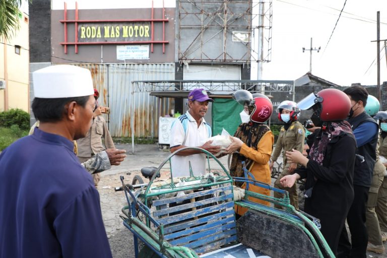 Naik Motor, Istri Bupati Sampang Bagikan Sembako ke Tukang Becak
